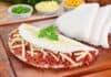 Conheça os benefícios da TAPIOCA para sua Dieta Tapioca recheada com carne, queijo e acompanhamentos em uma tábua de madeira.