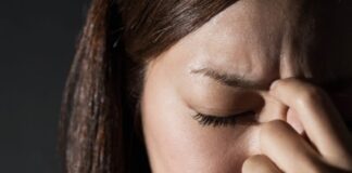 10 motivos para você fazer Musculação para Ansiedade (mantenha o controle) Mulher com dor de cabeça, ansiedade e estresse, buscando alívio com musculação.