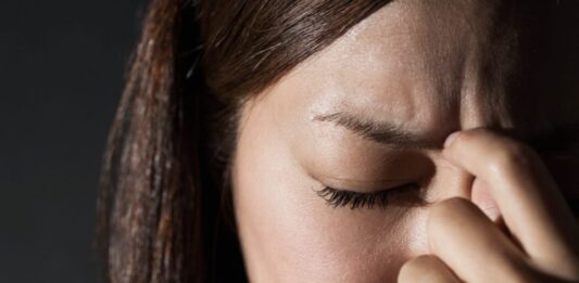 10 motivos para você fazer Musculação para Ansiedade (mantenha o controle) Mulher com dor de cabeça, ansiedade e estresse, buscando alívio com musculação.