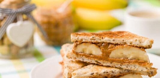 10 Alimentos para comer no Café da Manhã (para Hipertrofia) Sanduíche de banana e mel, ideal para café da manhã saudável.