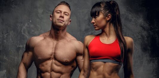 Como é feito o Ciclo de Oxandrolona? (Prós e Contras) Homem e mulher com músculos definidos em treino de musculação.