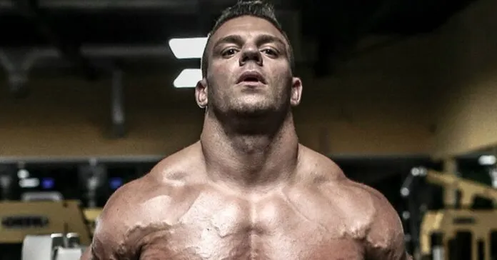 Homem musculoso treinando ombros Homem musculoso fazendo treino de ombro na academia.