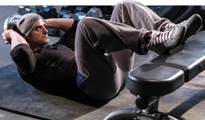 Homem fazendo abdominal no solo Homem realizando abdominal no solo para fortalecer o core.