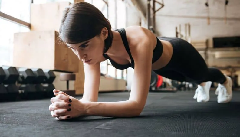 Mulher fazendo exercício de Crossfit no chão para perder barriga.