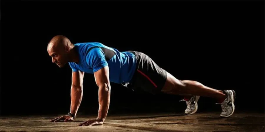 Homem realizando push-up, exercício de cardio para emagrecimento.