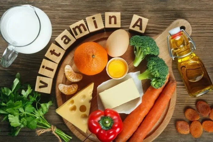Variedade de alimentos que fornecem Vitamina A, incluindo cenoura, brócolis, queijo e ovos.