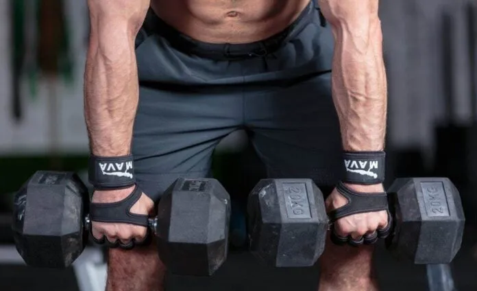 Homem levantando halteres para treino Pessoa treinando força com halteres em academia.