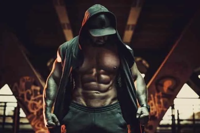 Homem musculoso treinando na academia com foco na hipertrofia.