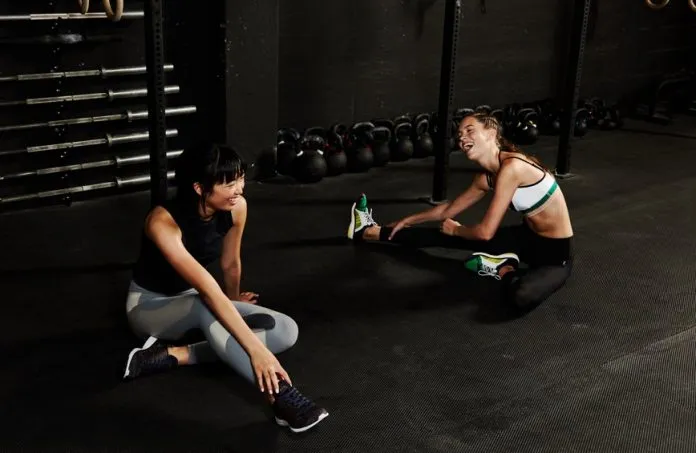 Dicas de treino para saúde mental Duas mulheres conversando após treino na academia.