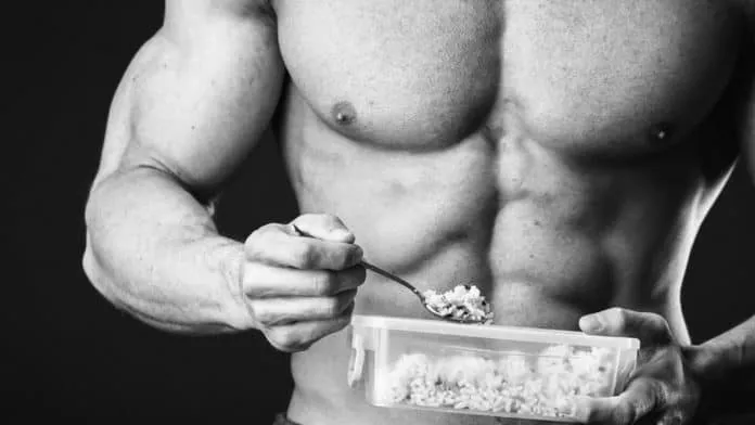Homem musculoso comendo alimentos saudáveis antes de dormir.