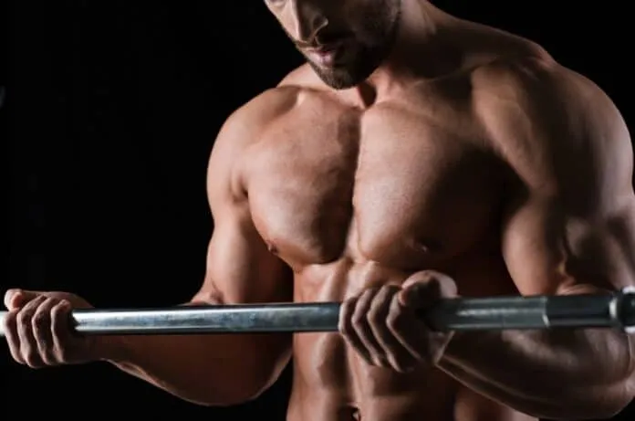 Homem treinando bíceps com barra Homem musculoso treinando bíceps com barra em treino de força.