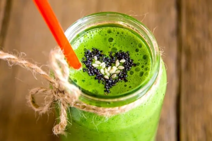 Suco verde saudável com sementes e canudo laranja.
