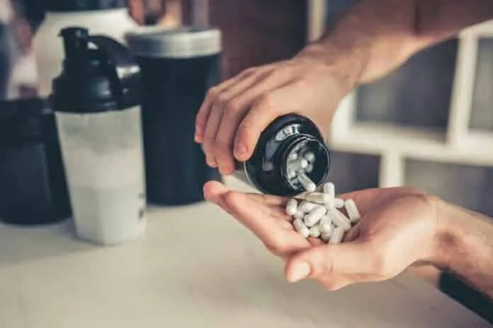 Suplemento de BCAA para Iniciantes Pessoa despejando comprimidos de BCAA em uma mão.