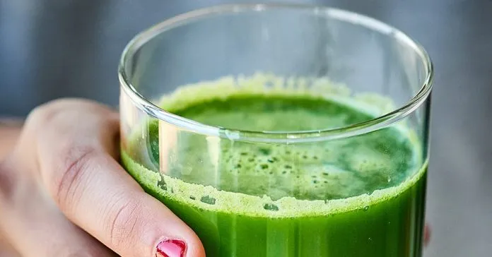 Copo com suco detox verde feito com ingredientes naturais.
