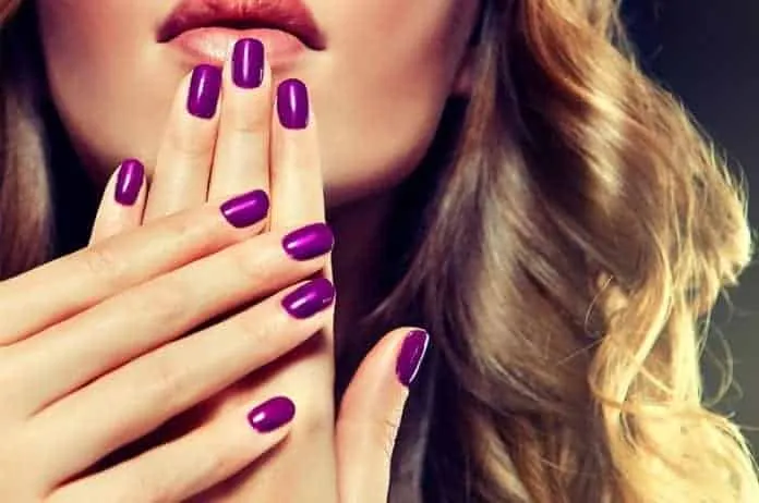Unhas e cabelos saudáveis com suplementos Mãos com unhas e cabelo bem cuidados, destacando a beleza e saúde.