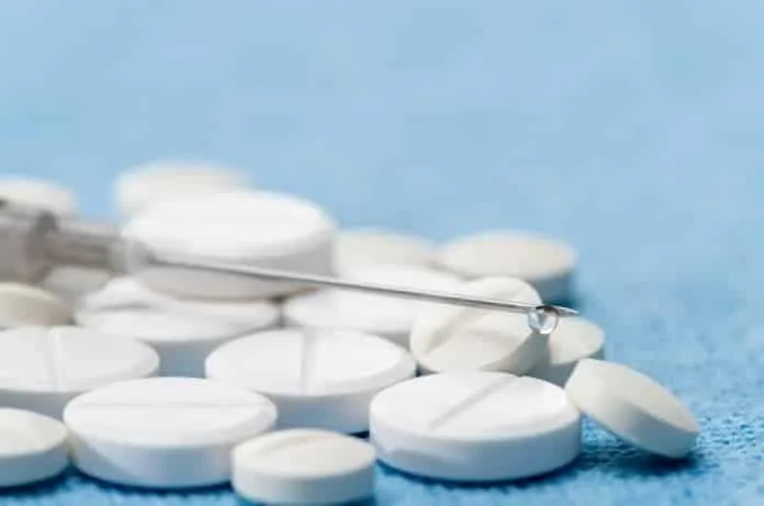 Pílulas contraceptivas e remédios com agulha e pinça.