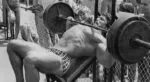 Arnold Schwarzenegger realizando treino de peito avançado.