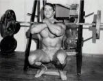 Arnold Schwarzenegger fazendo agachamento com barra pesada.