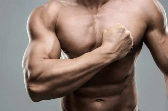 Homem musculoso mostrando força com o punho fechado.