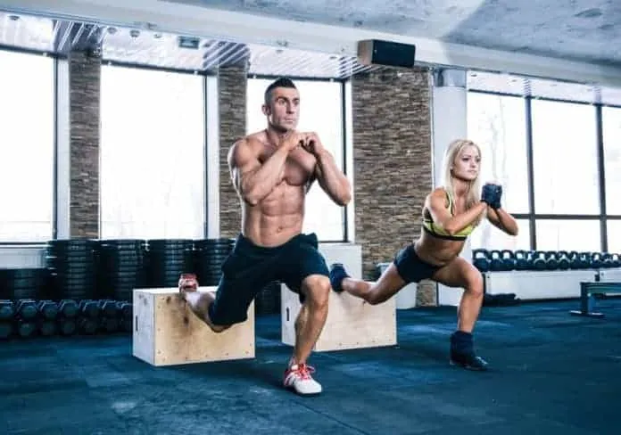 Exercícios de perna com peso corporal Homem e mulher fazendo exercícios de perna na academia.