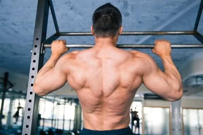 Treino de Costas com Aparelhos Básicos Homem treinando costas com barra em academia, foco na musculatura das costas.