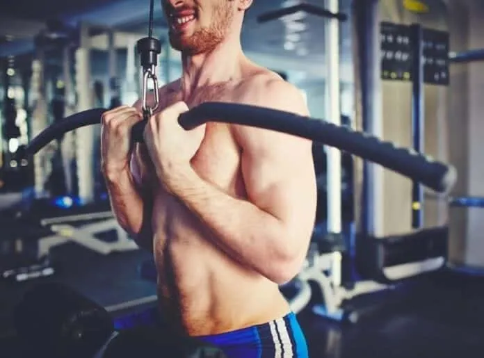 Homem fazendo treino de força na academia Homem treinando força com barra na academia, foco em ganho de massa muscular.