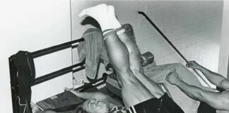 Treino de Abdômen do Arnold Schwarzenegger (Avançado) Homem fazendo exercício avançado de abdômen com peso na academia.
