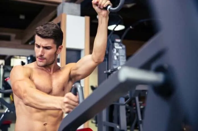 Homem treinando musculação na academia Homem musculoso treinando na academia com foco e força.