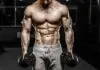 Lista dos Top 5 Anabolizantes para Primeiro Ciclo Homem musculoso treinando com halteres na academia.