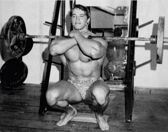 Treino de Glúteos do Arnold Schwarzenegger Arnold Schwarzenegger fazendo agachamento com barra para glúteos.